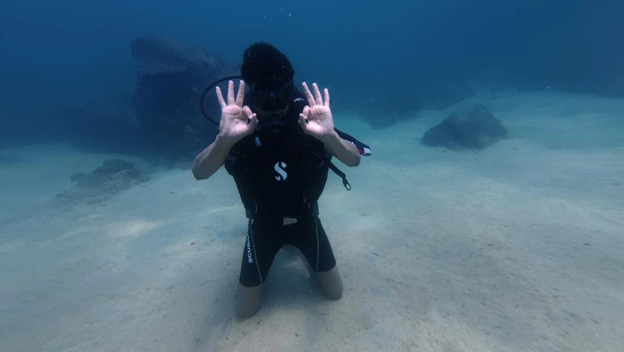 Scuba diver giving the OK signal underwater at Coral Garden reef, Trincomalee