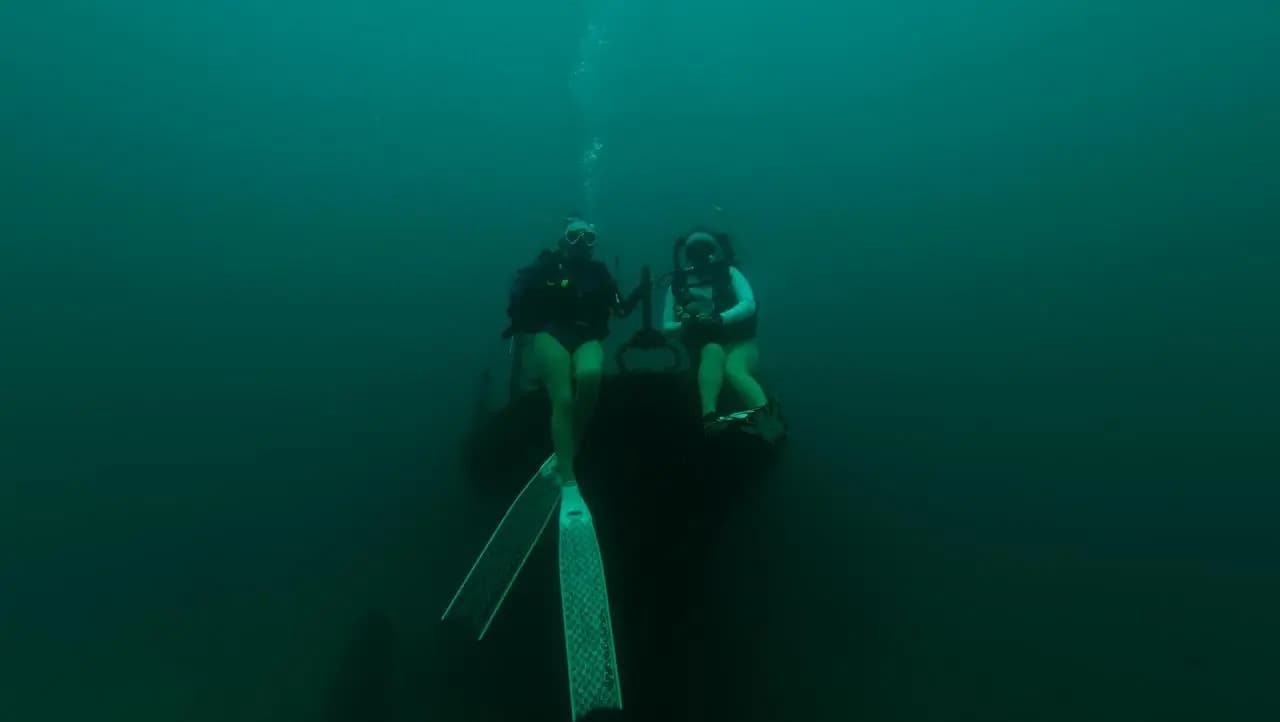 Two female scuba divers sitting on a shipwreck in Trincomalee